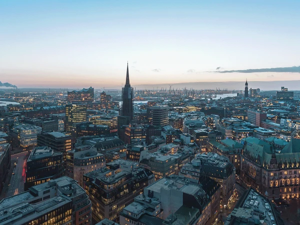 Blick von oben auf beleuchtetes Hamburg bei Sonnenuntergang