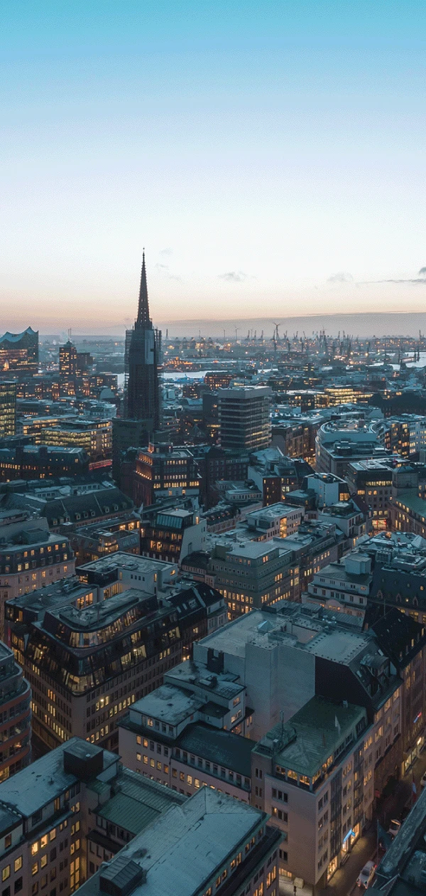 Blick von oben auf beleuchtetes Hamburg bei Sonnenuntergang