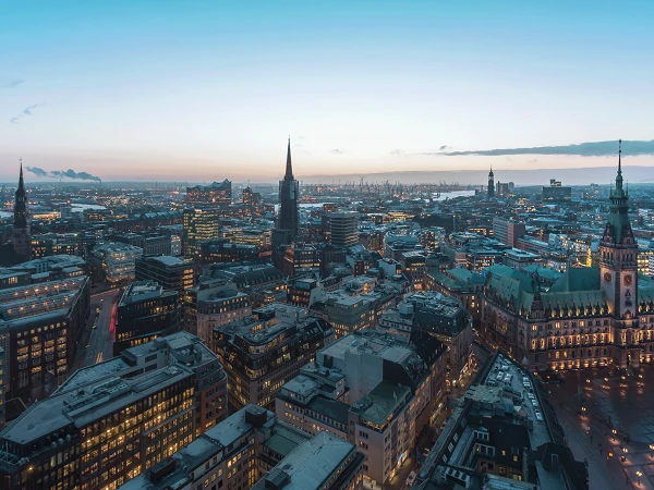 Blick von oben auf beleuchtetes Hamburg bei Sonnenuntergang