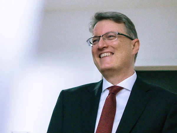 lachender Mann mit Anzug und Krawatte