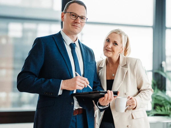 Mann und Frau im modernen Büro mit iPad und Kaffee