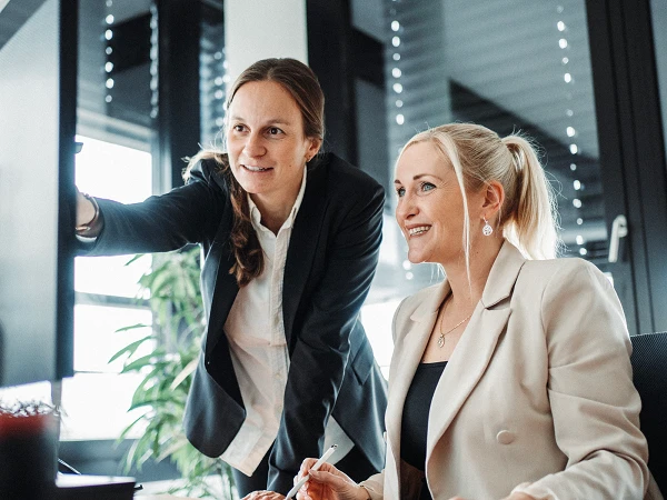 Zwei Frauen arbeiten zusammen in modernem Büro am Computer