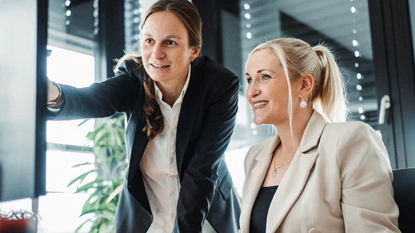 Zwei Frauen arbeiten zusammen in modernem Büro am Computer